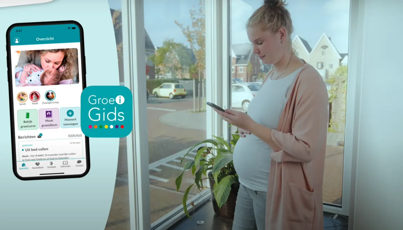 Een zwangere mevrouw die op haar telefoon kijkt naar de app GroeiGids.