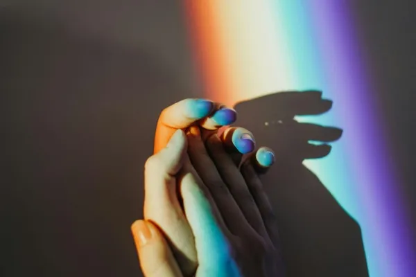 Handen vast houden met regenboog op de achtergrond