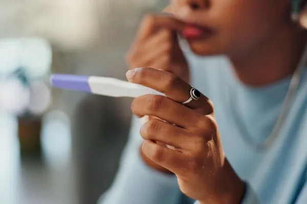 Vrouw die naar een zwangerschaptest zit te kijken